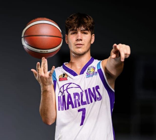 Basketball player in Marlins jersey spinning a ball and pointing, celebrating recruitment success through AllRecruit.