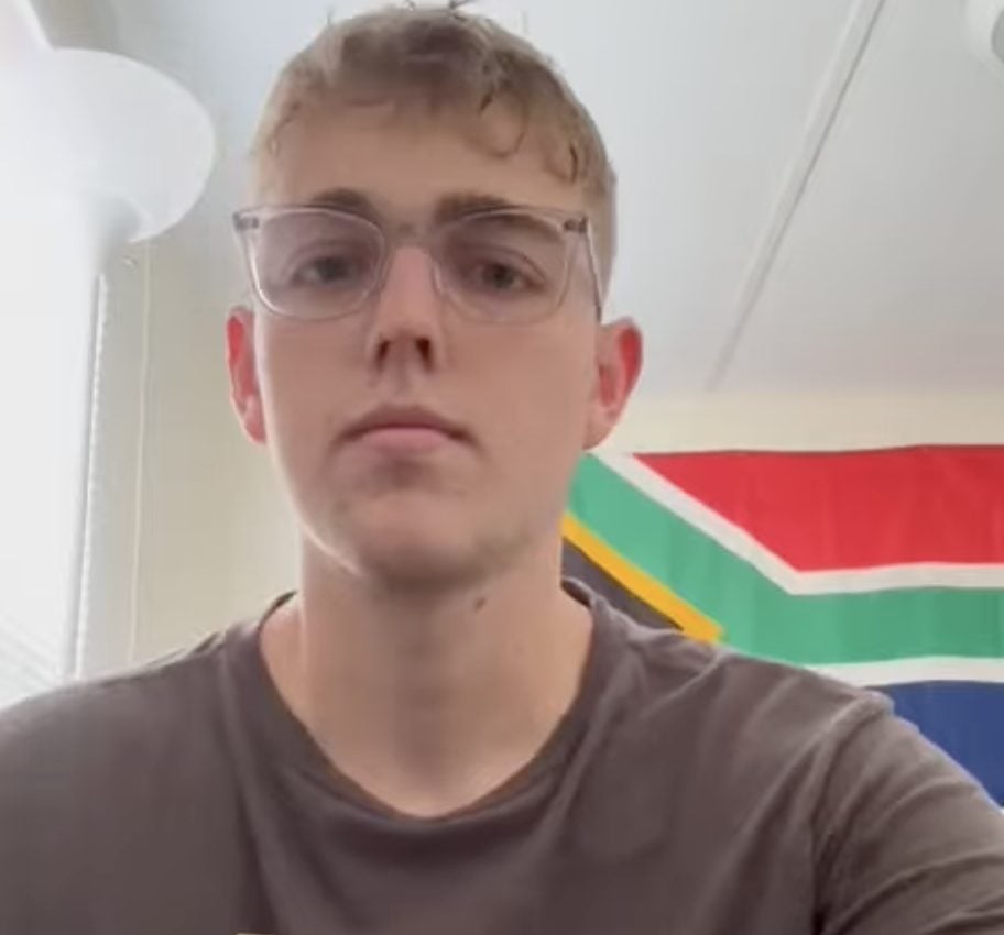 Male student-athlete gives video testimonial, with South African flag in background, about his recruiting journey.